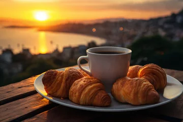 Stoff pro Meter cup of coffee and french croissant on table, balcony with view of beautiful landscape, still life, sea and mountains, resort town, sunset © soleg