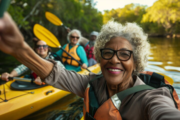 A senior woman with a beaming smile takes a selfie with friends during a kayak outing, surrounded by lush greenery.