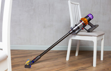 Modern stick vacuum cleaner in home interior