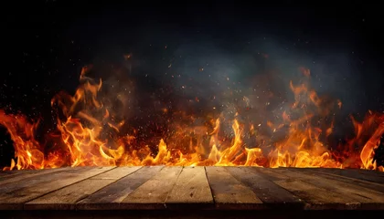 Poster wooden table with Fire burning at the edge of the table, fire particles, sparks, and smoke in the air, with fire flames on a dark background to display products © blackdiamond67