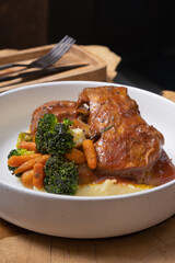 Close up beef ribs in barbecue sauce with vegetables and mashed potatoes in plate on wooden table