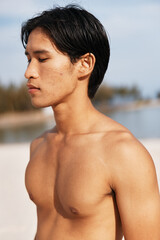 Active Asian Man Enjoying a Sunset Run on the Beach, Embracing the Fitness Lifestyle