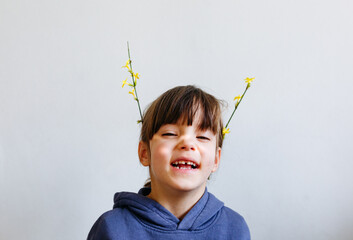 portrait of smiling little girl with flowers on top of the head