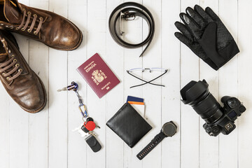 Still life with hiking boots, camera, Spanish passport, carbon fiber wallet and winter gloves on a...