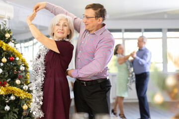 Adult man and elderly woman dance ballroom dance waltz in studio