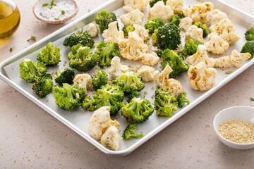 Broccoli and cauliflower florets on a sheet pan ready to be roasted - 755236549