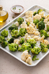 Broccoli and cauliflower florets on a sheet pan ready to be roasted - 755236599