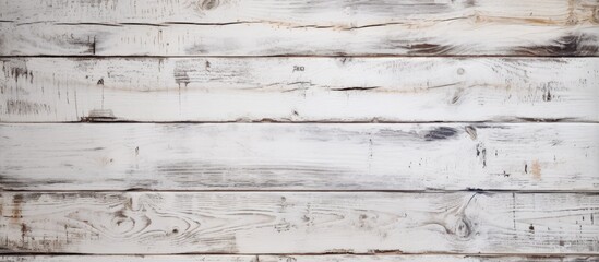 A weathered wooden wall painted in white, showing signs of age and wear. The white paint is peeling off in some areas, revealing the natural wood underneath.
