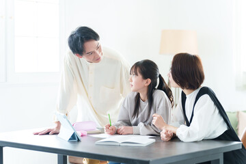 勉強をする女の子に教える両親