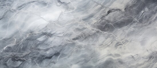 Obraz premium A close-up view of a grey marble texture with intricate natural patterns, creating a visually striking and detailed abstract background.