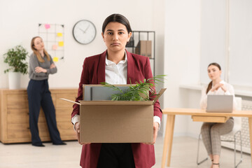 Unemployment problem. Woman with box of personal belongings in office