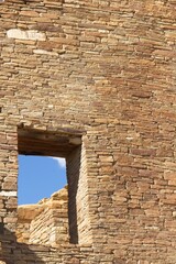 Windows in a wall at the Chaco Canyon Pueblo, New Mexico, with clouds in a blue sky.