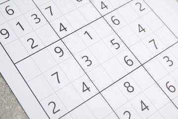 Sudoku puzzle on grey table, closeup view
