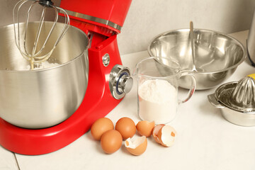Modern red stand mixer, different ingredients and squeezer on white marble table