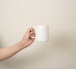 hand is holding a mug or glass on a white isolated background