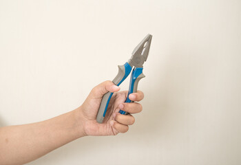 hand is holding a pliers on a white isolated background