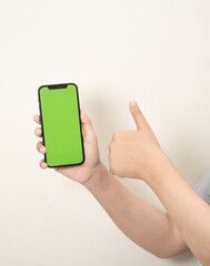 hand is holding a phone with green screen on a white isolated background