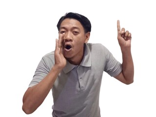 Fototapeta premium Shocked Asian man wearing gray t-shirt is pointing at the copy space beside him, isolated by white background