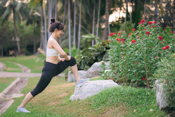 Sportswoman. Fit young Asian woman with sportswear stretching muscle in park before running and enjoying healthy outdoor. Fitness runner girl in public park. Wellness being concept