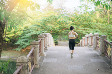 Fototapeta na wymiar asian woman jogger, running over the bridge in public park.