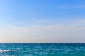 Ocean waves, clear seas and skies, buoys in the sea.