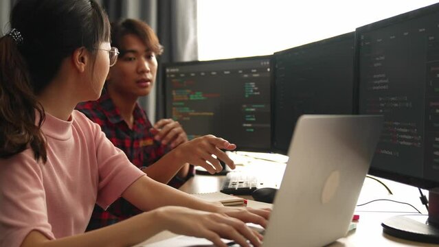 Slow motion back end software developer engineer for computer programming working together on debugging writing computing code, solving complex algorithms display on monitor in office. Burgeoning