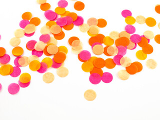 Close view of bright pink, orange and peach confetti on white background