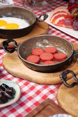  salami sausage in pan served with cheese on table 