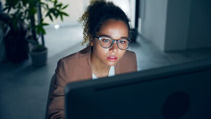 Black woman working with desktop computer in office.