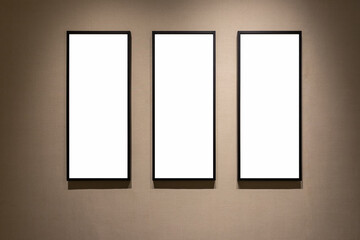 three blank frames on a wall with wallpaper