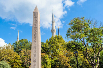 Egyptian obelisk with hieroglyphics in front of a mosque on a clear day, in Istanbul, Turkiye