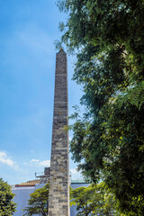 Tall obelisk undergoing restoration, scaffolded against a clear sky with foliage, in Istanbul, Turkiye