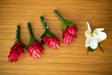 A boutonnière is a floral decoration, typically a single flower or single stick, worn on the lapel of a tuxedo or suit jacket.