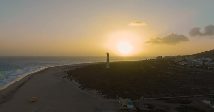 Lighthouse of Jandia Morro Jable on sunset with the city behind