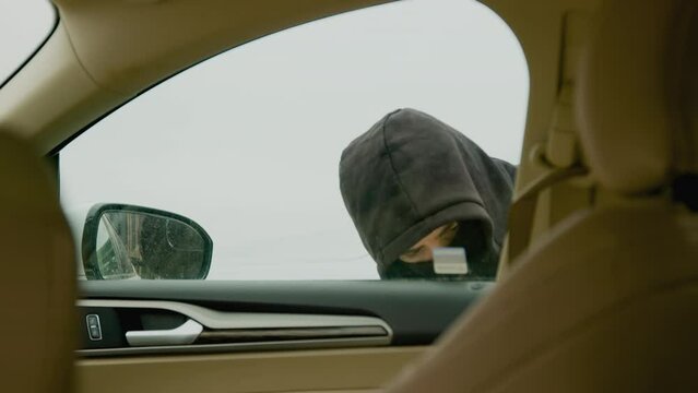 Adetermined hooded man attempts to unlock the vehicle. The atmosphere crackles with suspense as the thief works tirelessly to gain access to the car, heightening the drama