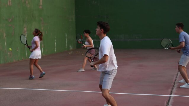 Young man playing frontenis on outdoor pelota court during training. Man playing Basque pelota speciality.