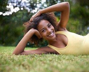 Naklejka na ściany i meble Happy, grass and portrait of black woman in nature for relaxing, calm and peace in park. Smile, garden and person laying outdoors for holiday, vacation and weekend for wellness, fresh air and joy