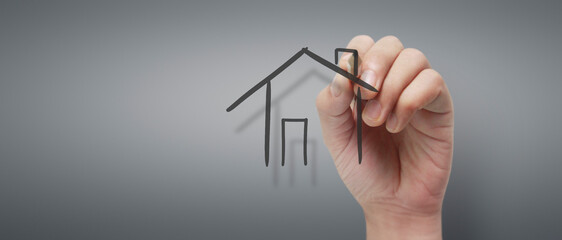 Male hand drawing house in whiteboard