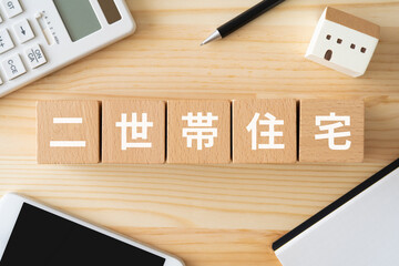 二世帯住宅の文字が入ったブロック、おもちゃの家、電卓