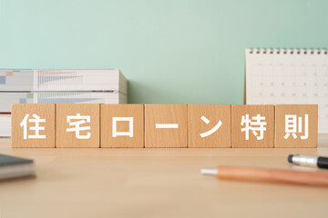 住宅ローン特則の文字が入ったブロックが置かれたデスク