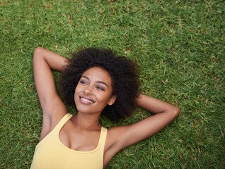 Happy, grass and above of black woman in park for thinking, wondering and relax in nature. Smile, garden and top view of person laying outdoors for holiday, vacation and weekend for calm or peace