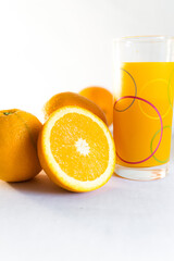 glass of orange juice and oranges