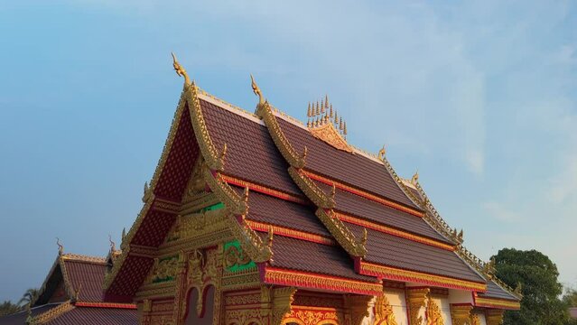 Traditional beautifully decorated Laos architecture, arched roof on old temple pagoda. Drone orbit rotate.