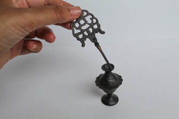 Asian female hand holding an old make up tool used as eye liner. Kohl eyeliner, an ancient metal...