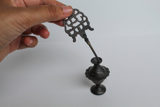 Asian female hand holding an old make up tool used as eye liner. Kohl eyeliner, an ancient metal package, which contain black powder