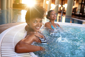 Excited woman, portrait and relax with water in jacuzzi at hotel, resort or hot tub spa together....