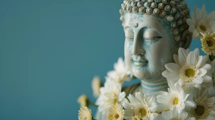 Tuinposter Buddha statue in White color with white flowers around, Buddha Statue with Blue Background, Buddhist holy day commemorating Siddhartha Gautama. ai generated © Azmee