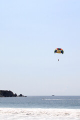 Parasailing, Parascending or Parakiting is an aquatic activity where a person attached to a parachute is towed by a boat at speed, causing them to rise above the water