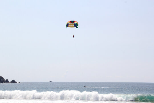 Parasailing, Parascending or Parakiting is an aquatic activity where a person attached to a parachute is towed by a boat at speed, causing them to rise above the water