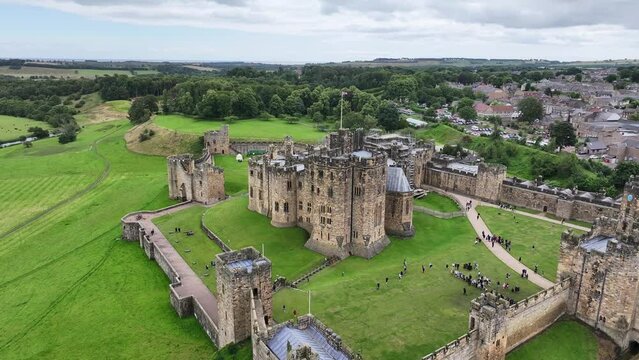 Medieval Alnwick Castle, England UK. Aerial View of Landmark, Walls and Green Landscape, Drone Shot 60fps